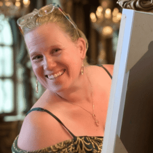 Heidi Neilson looking at the camera and smiling while painting at a wedding