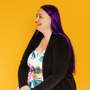 Wedding coach Heidi Thompson looking to the left and smiling on a bright yellow background